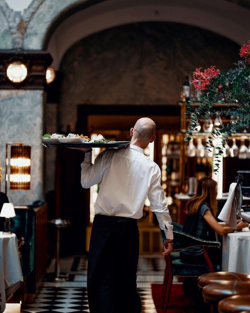 Bank Hotel, A Member Of Small Luxury Hotels Stoccolma Esterno foto A waiter carrying a tray of food