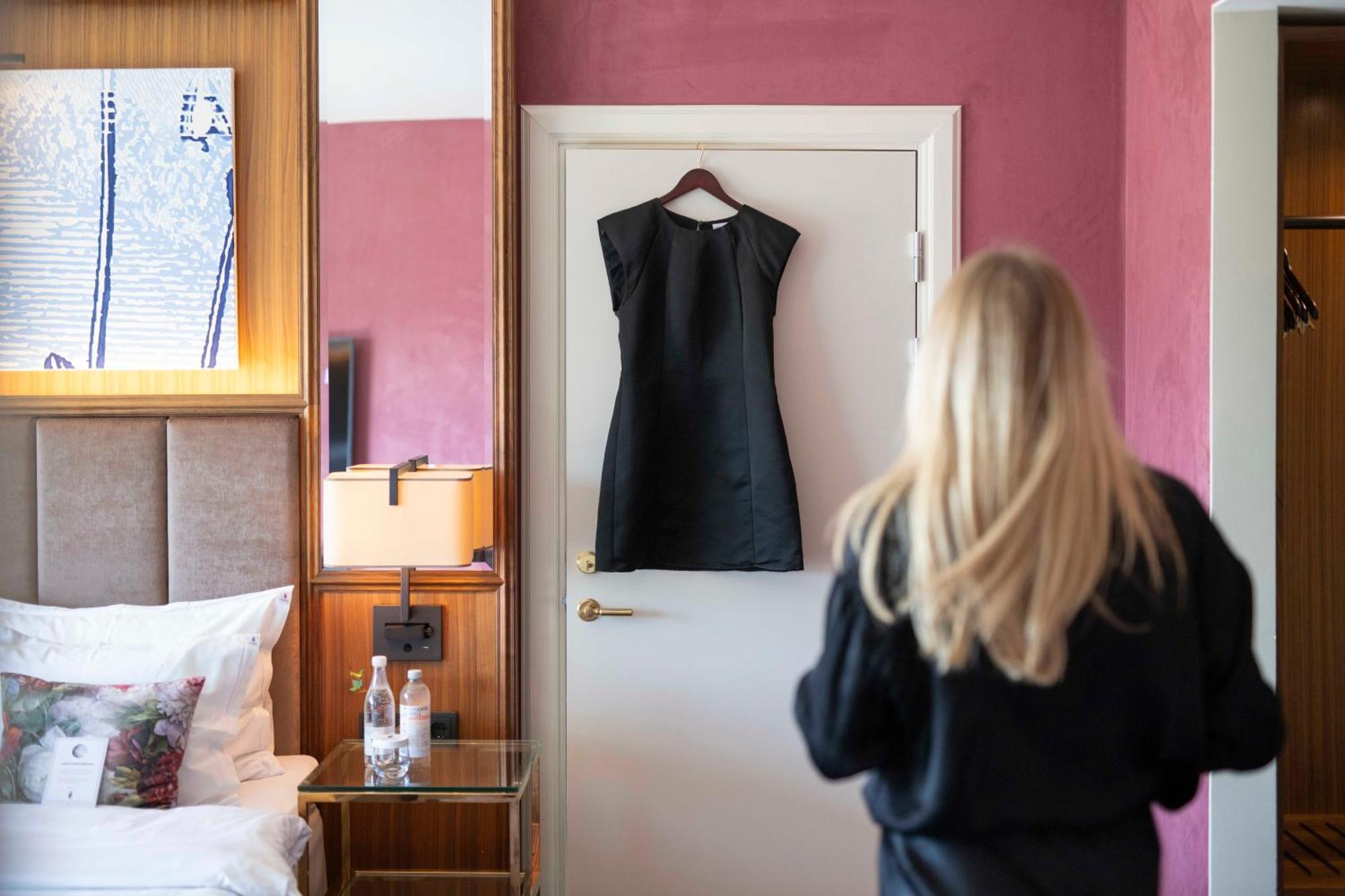 Bank Hotel, A Member Of Small Luxury Hotels Stoccolma Esterno foto A woman walking into a room with a black dress hanging on the door